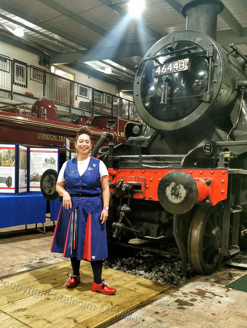 dancer standing in front of an engine in the shed